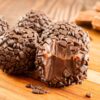 Foto mostra três brigadeiros em cima de um prato.