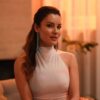 A foto mostra a atriz Ece Irtem. Mulher branca, cabelo castanho claro médio, sentada, usando blusa branca.