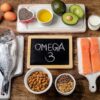 Foto mostra vários alimentos com ômega 3 em cima da mesa.