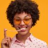 Imagem de uma mulher jovem com chiclete enrolado no dedo