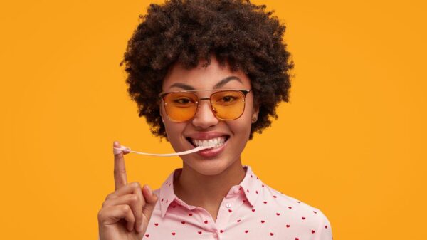 Imagem de uma mulher jovem com chiclete enrolado no dedo