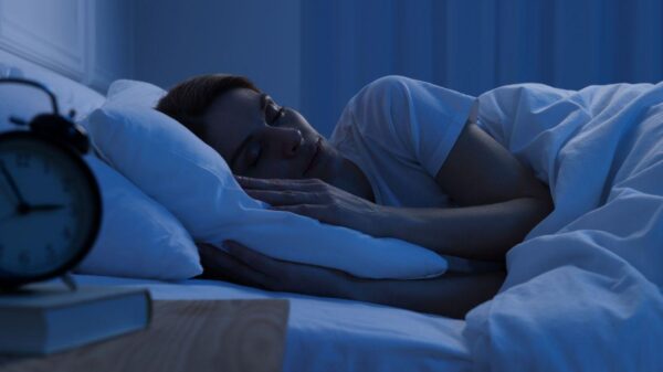 Imagem de uma mulher deitada na cama dormindo