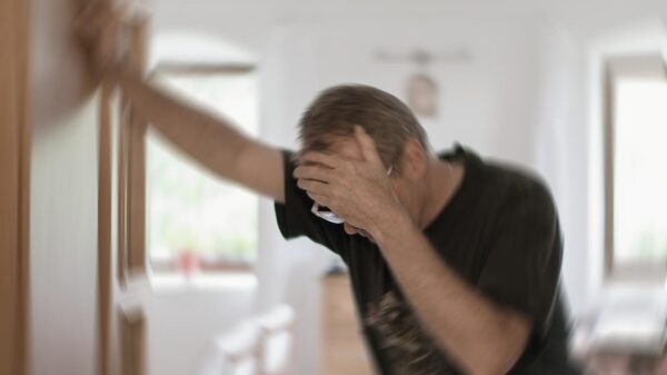 Foto mostra homem segurando na parede porque se sentiu tontura.