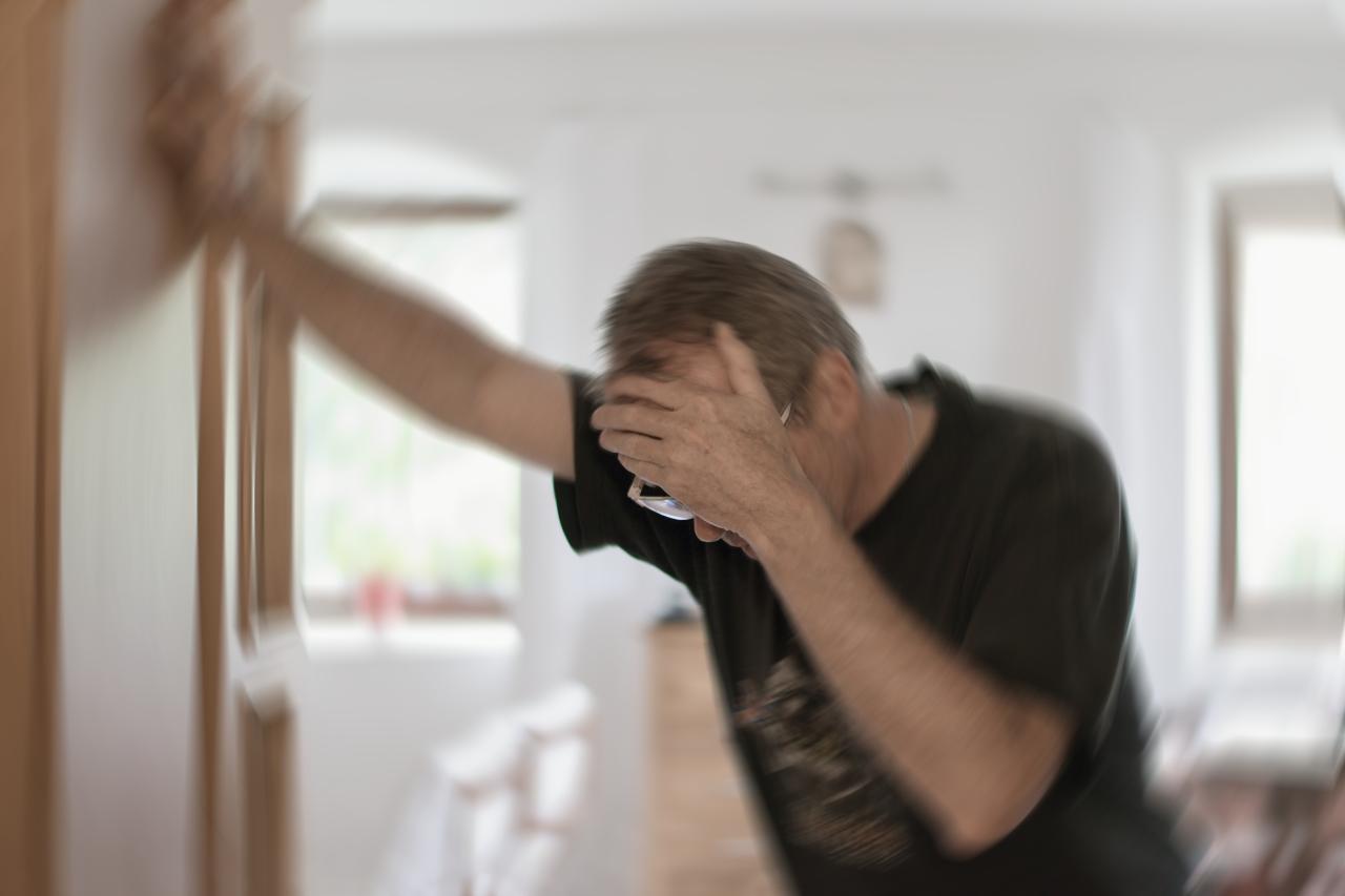 Foto mostra homem segurando na parede porque se sentiu tontura.