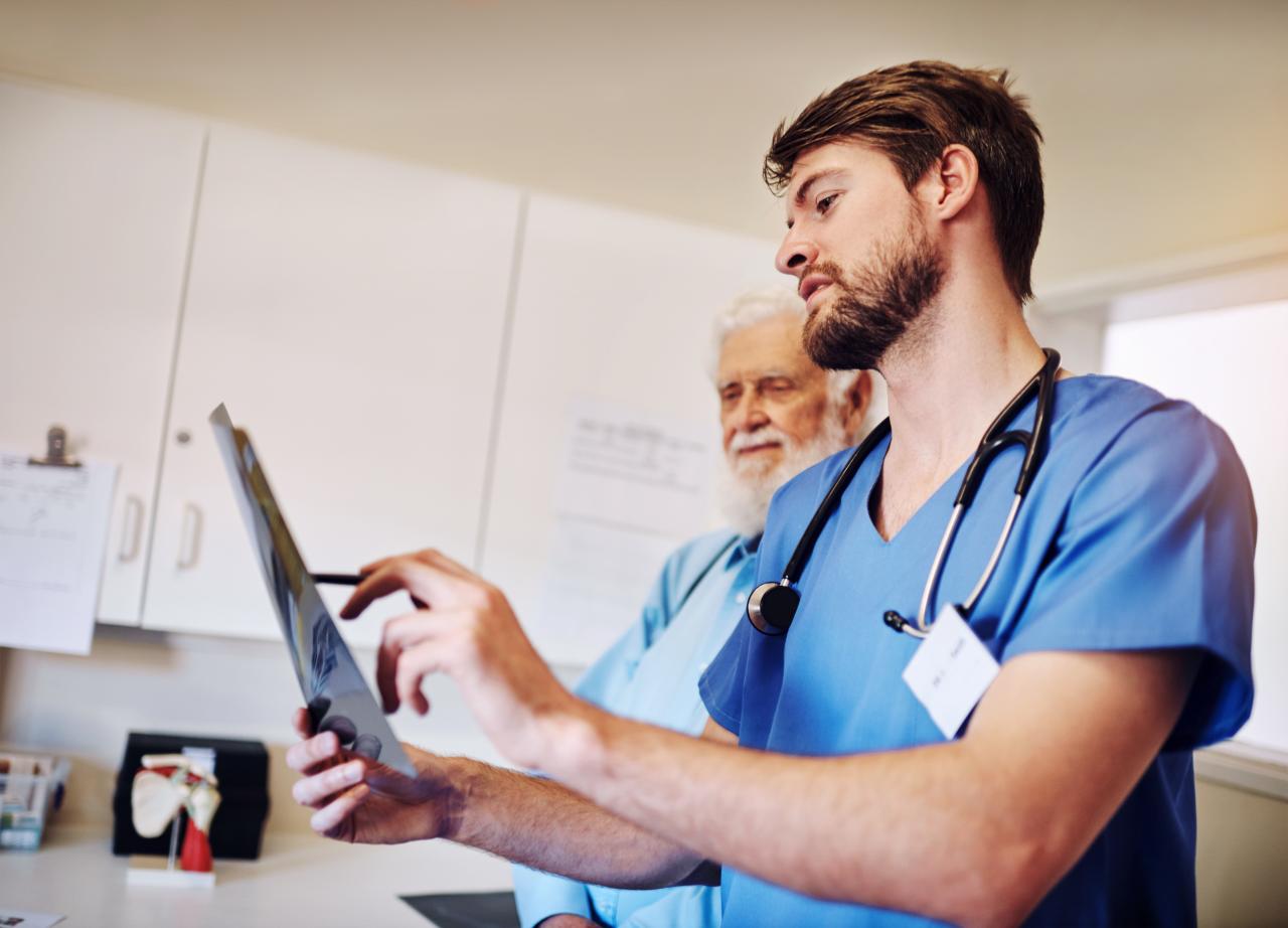 Foto mostra médico mostrando exame de imagem para um paciente.