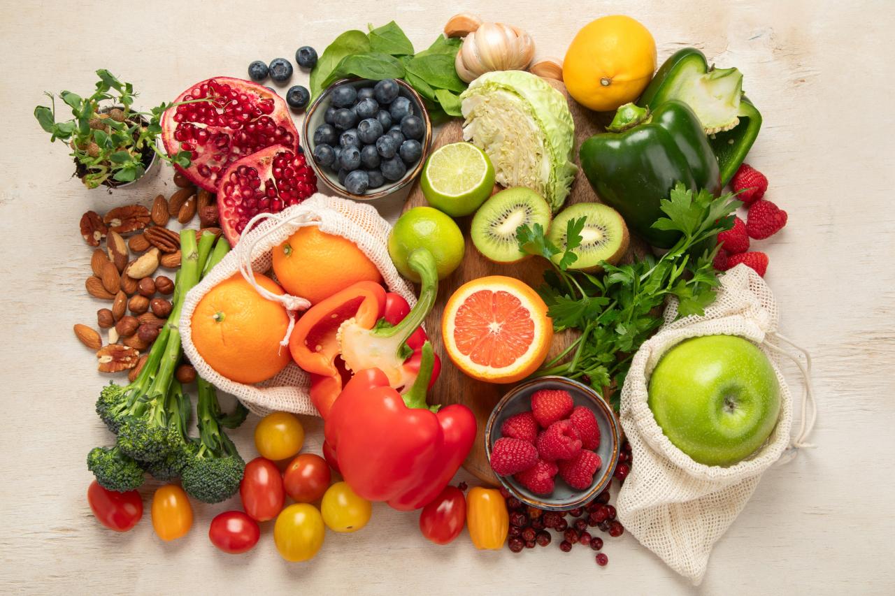 Foto mostra várias frutas, legumes em cima de uma mesa.