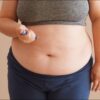 Imagem de uma pessoa aplicando caneta emagrecedora na barriga