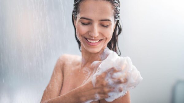 Imagem de uma mulher tomando banho com uma bucha cheia de espuma