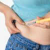 Imagem de uma pessoa aplicando caneta na barriga
