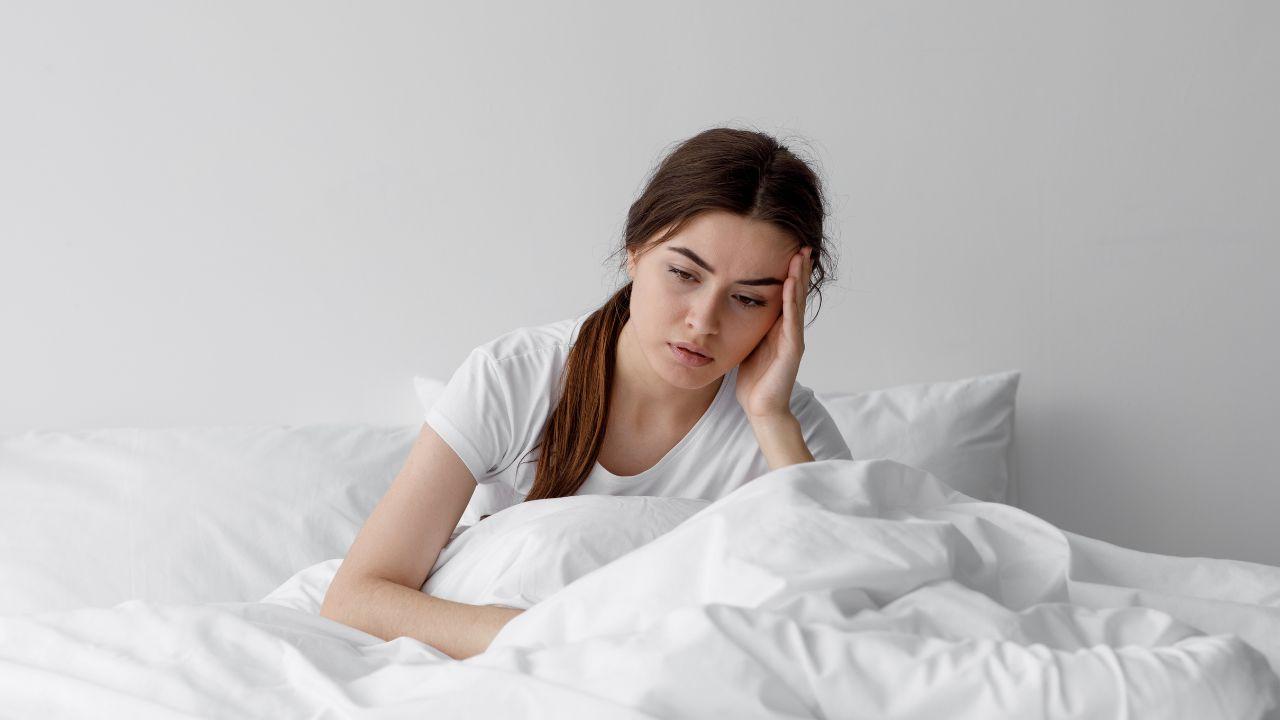 Imagem de uma mulher cansada na cama
