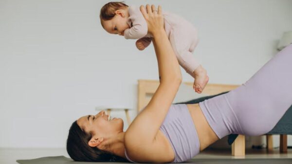 Imagem de uma mãe fazendo Yoga segurando um bebê
