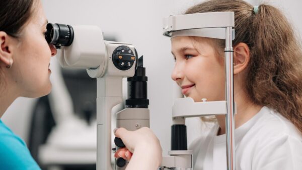 Foto mostra uma médica oftalmologista fazendo exame de visão em uma criança.