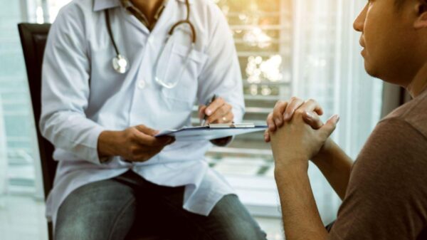 Homem sentado no consultório participando de consulta médica.