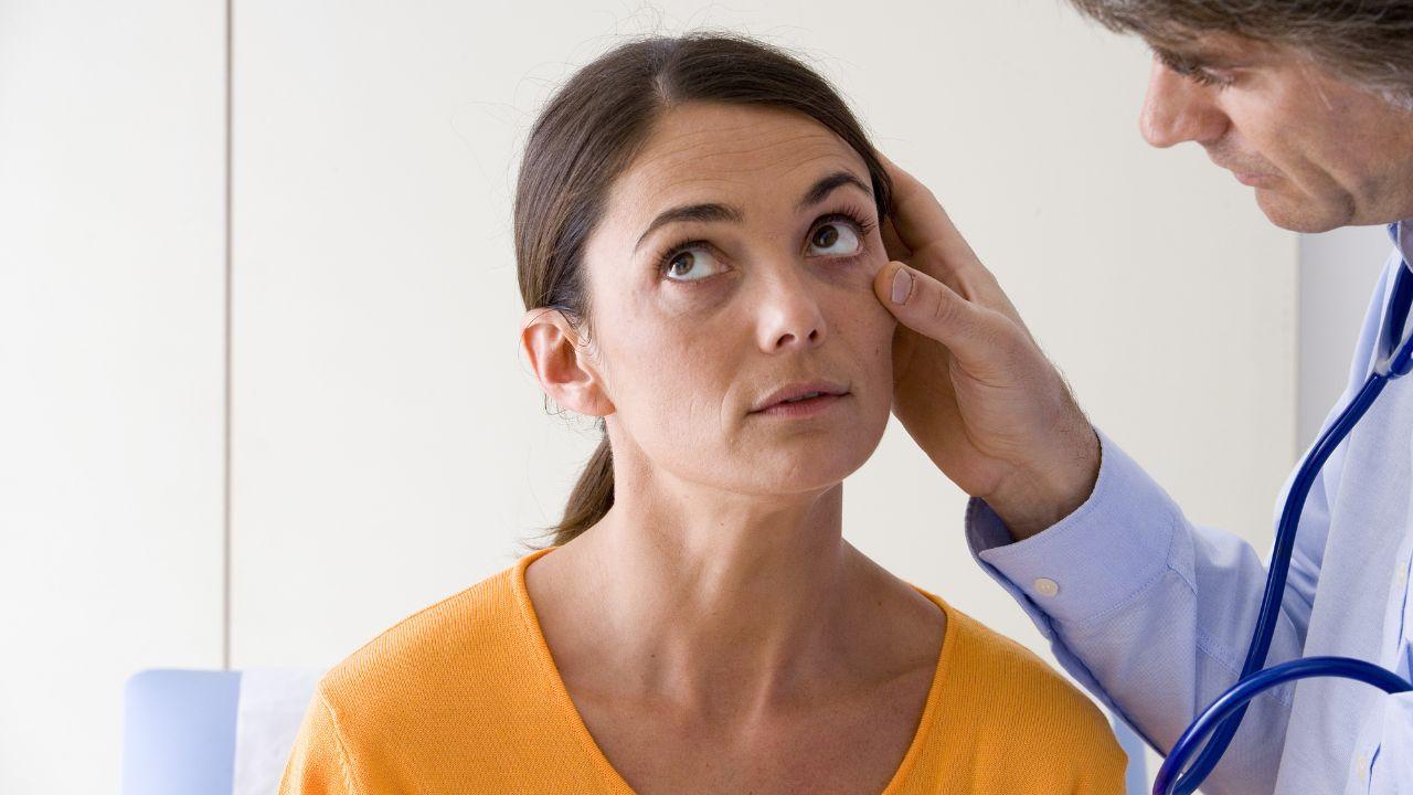 Imagem de um médico examinando os olhos de uma paciente
