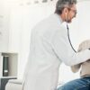 Imagem de um médico examinando o coração de um idoso