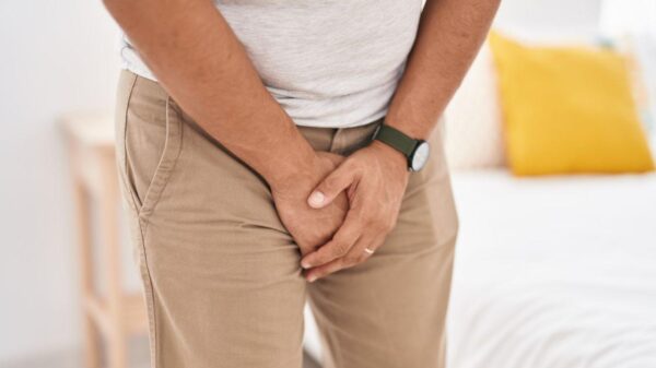 Imagem de um homem com a mão na região genital