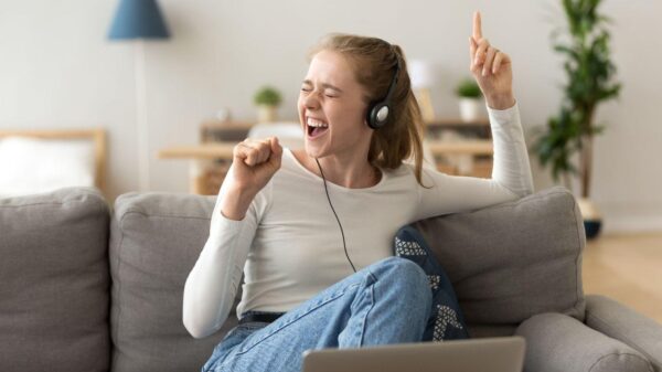 Imagem de uma jovem cantando com fone de ouvido