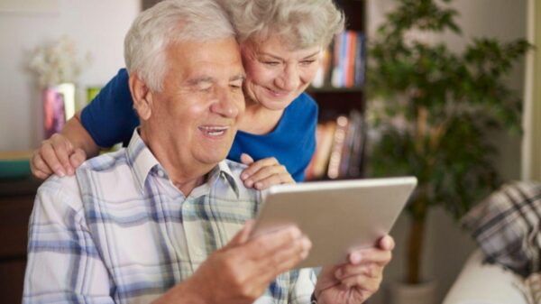Homem e mulher idosos mexendo em um tablet.