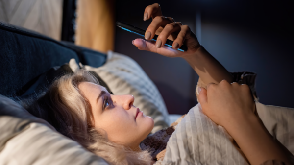 Mulher com celular pouco antes de dormir